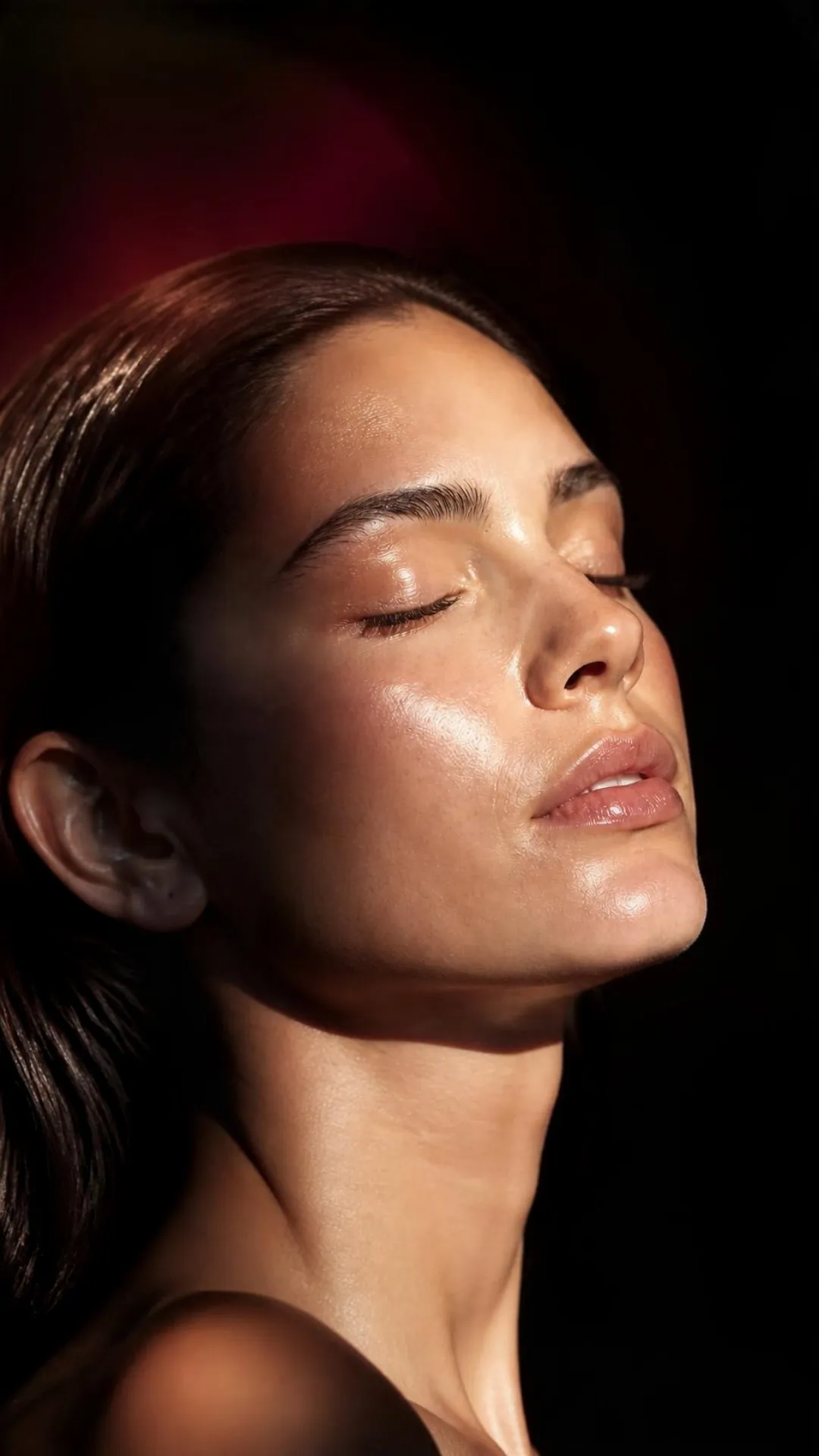 Close portrait of a woman with eyes closed in warm golden light